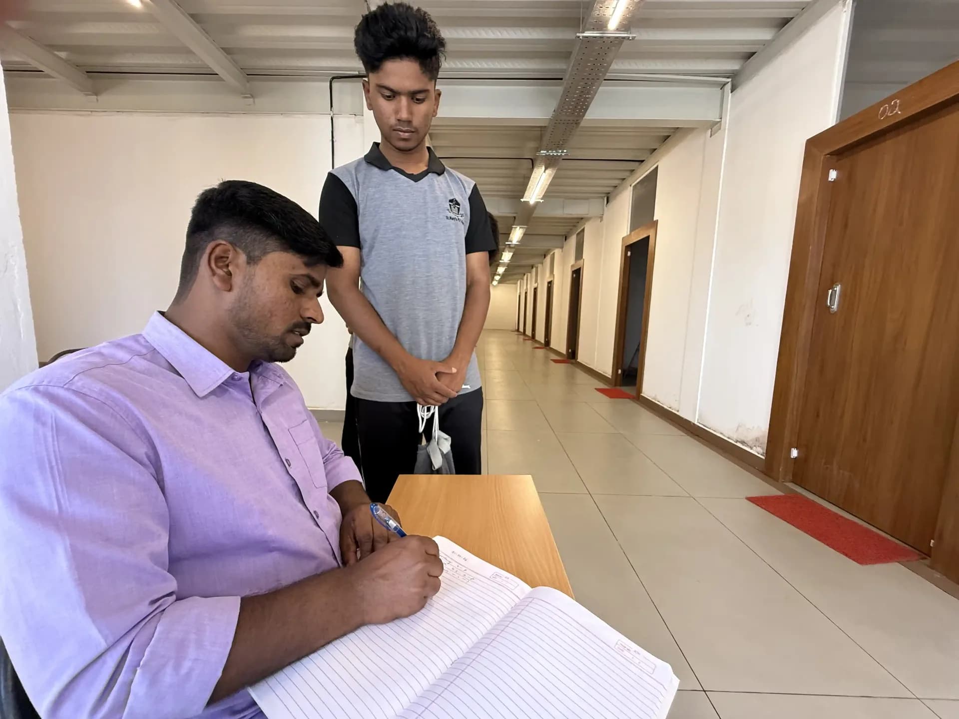 Warden checking in a student at Freddie House