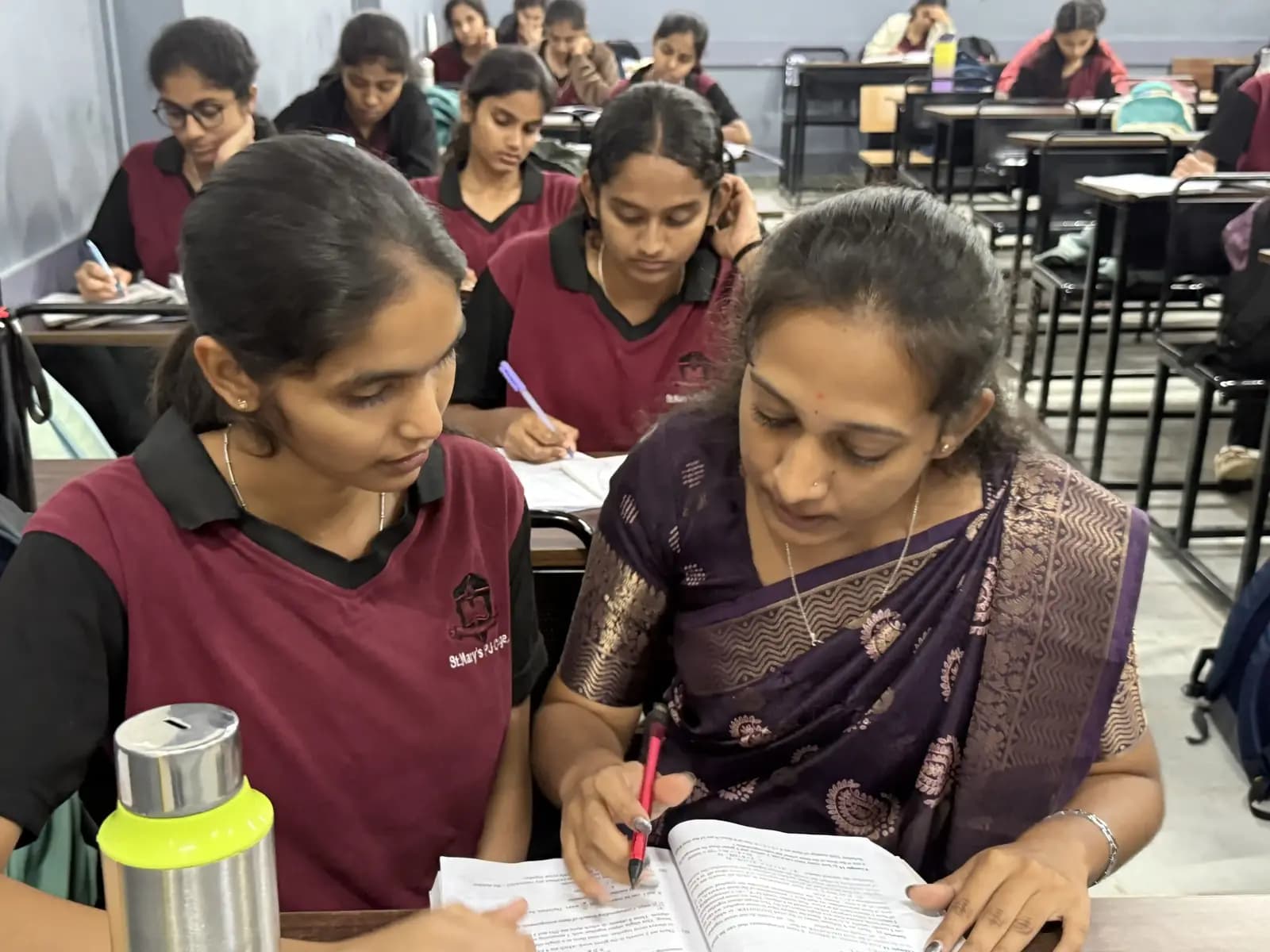 A teacher helping a Maggie House student during night study